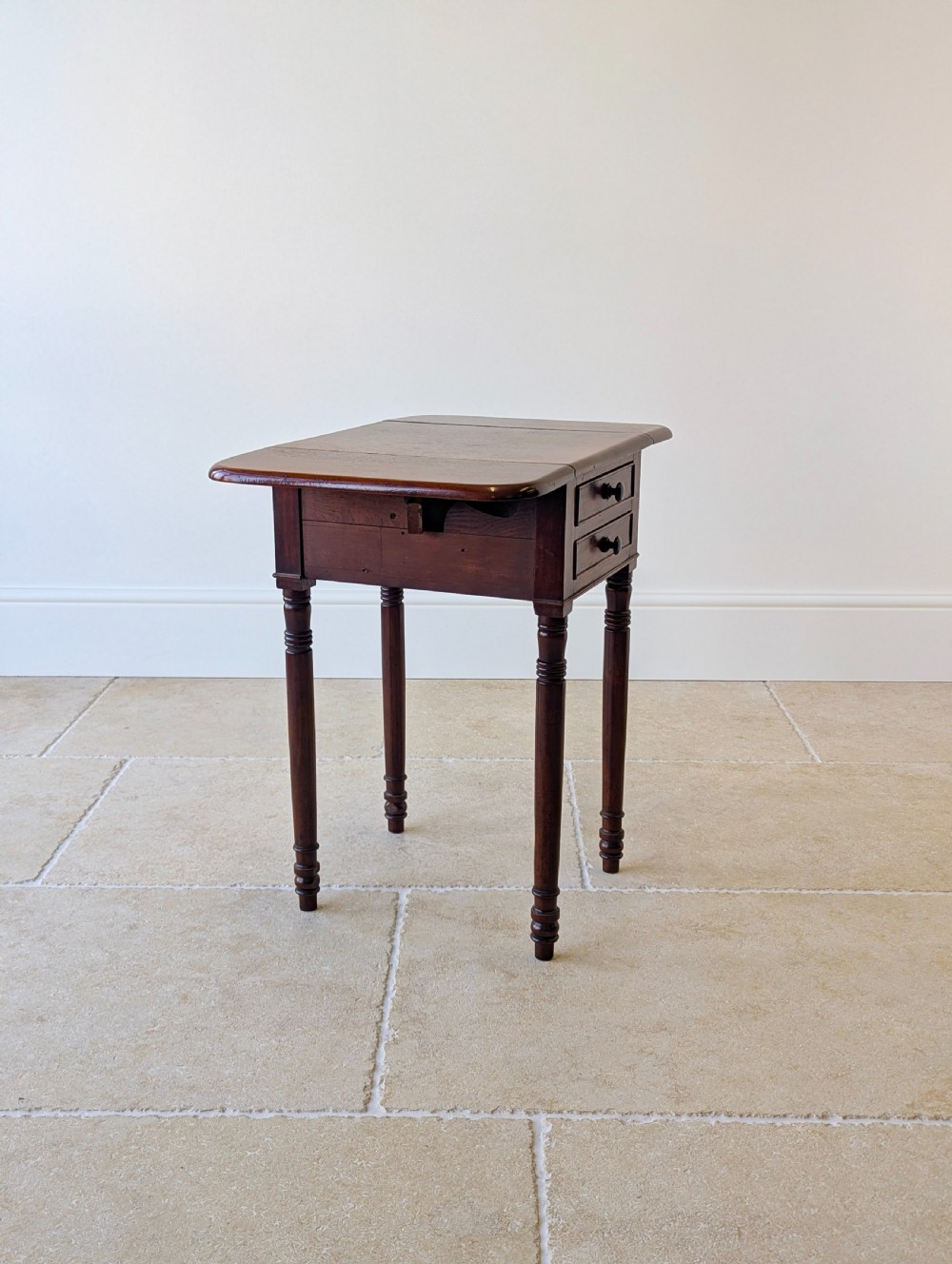 An early Victorian dark mahogany Pembroke work table with two drawers, turned legs, and two extended drop-leaf flaps. View XV