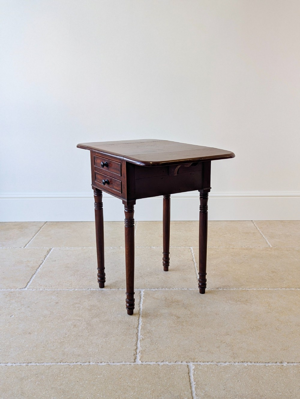 An early Victorian dark mahogany Pembroke work table with two drawers, turned legs, and two extended drop-leaf flaps. View XVI