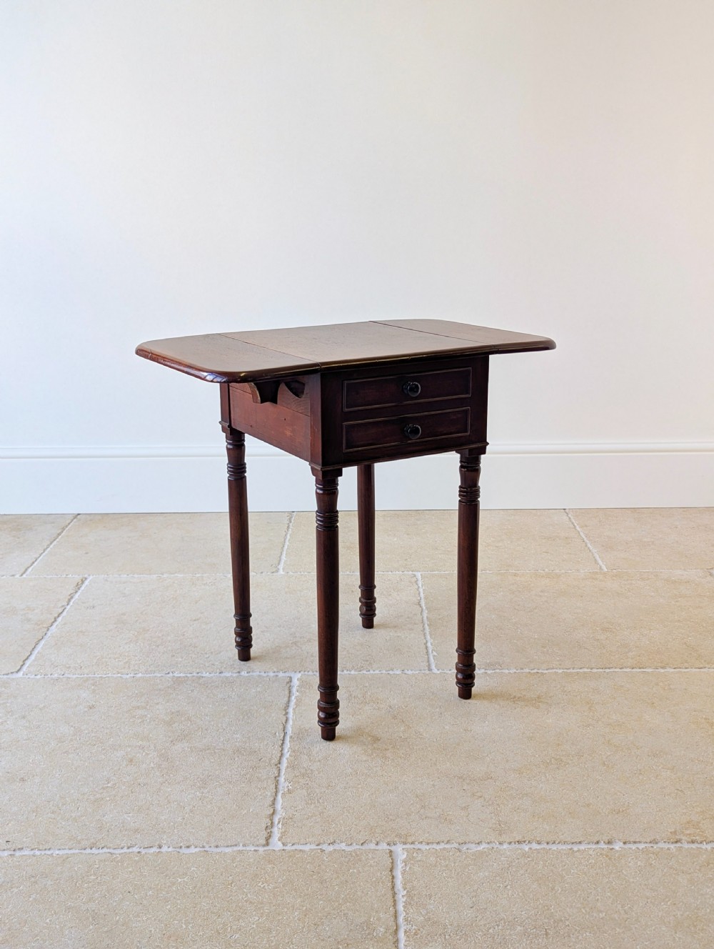 An early Victorian dark mahogany Pembroke work table with two drawers, turned legs, and two extended drop-leaf flaps. View XVII
