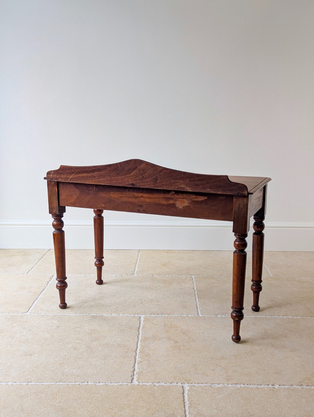 A Victorian mahogany writing table featuring two front drawers with dark turned knobs, a raised rear gallery upstand, and four turned legs. View XIV