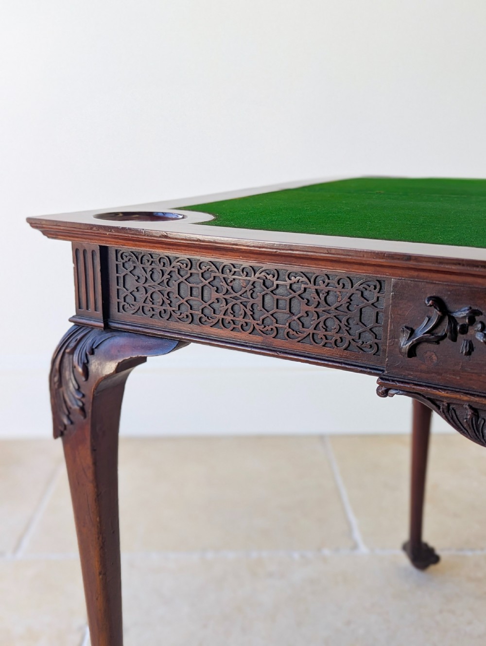 An Edwardian dark mahogany fold-over card table featuring carved cabriole legs, claw and ball feet, and blind fretwork along the apron. View IV