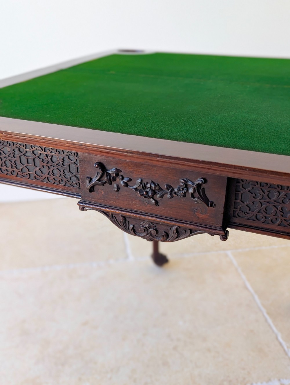 An Edwardian dark mahogany fold-over card table featuring carved cabriole legs, claw and ball feet, and blind fretwork along the apron. View VI