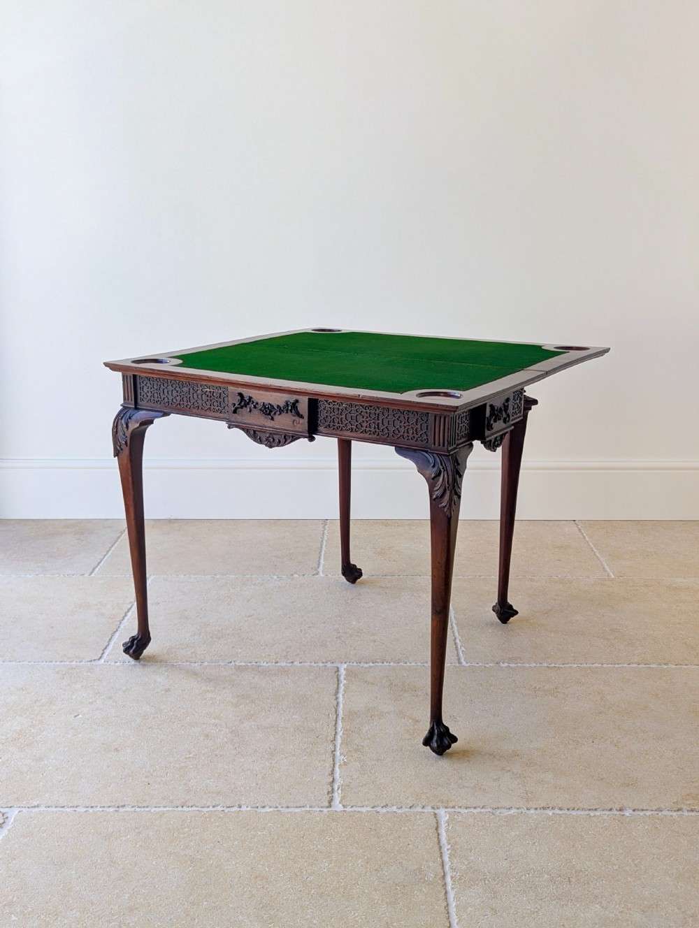 An Edwardian dark mahogany fold-over card table featuring carved cabriole legs, claw and ball feet, and blind fretwork along the apron. View VIII