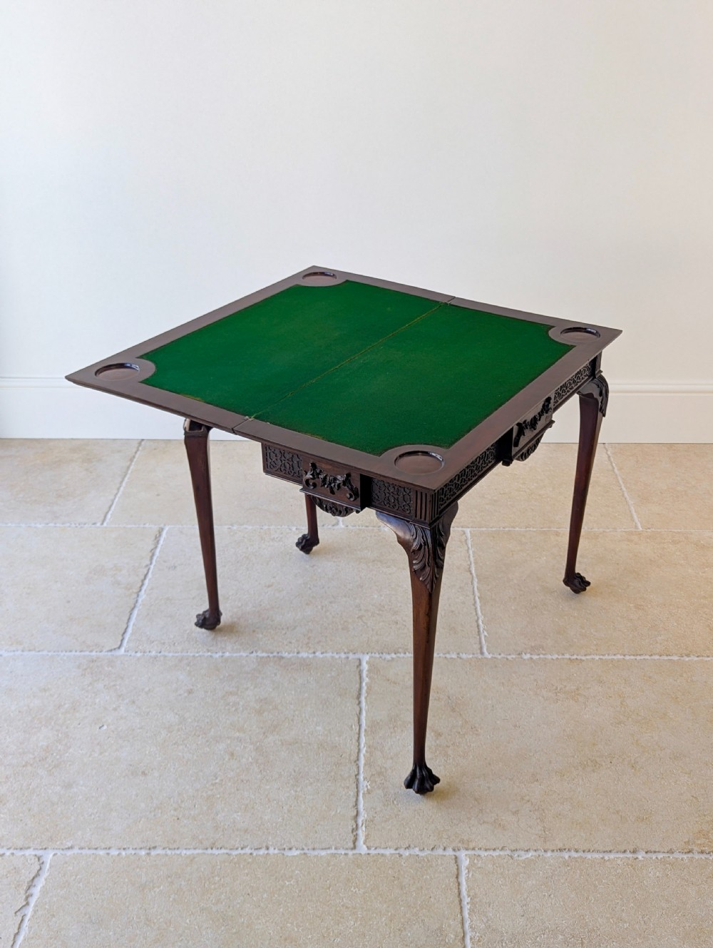An Edwardian dark mahogany fold-over card table featuring carved cabriole legs, claw and ball feet, and blind fretwork along the apron. View X