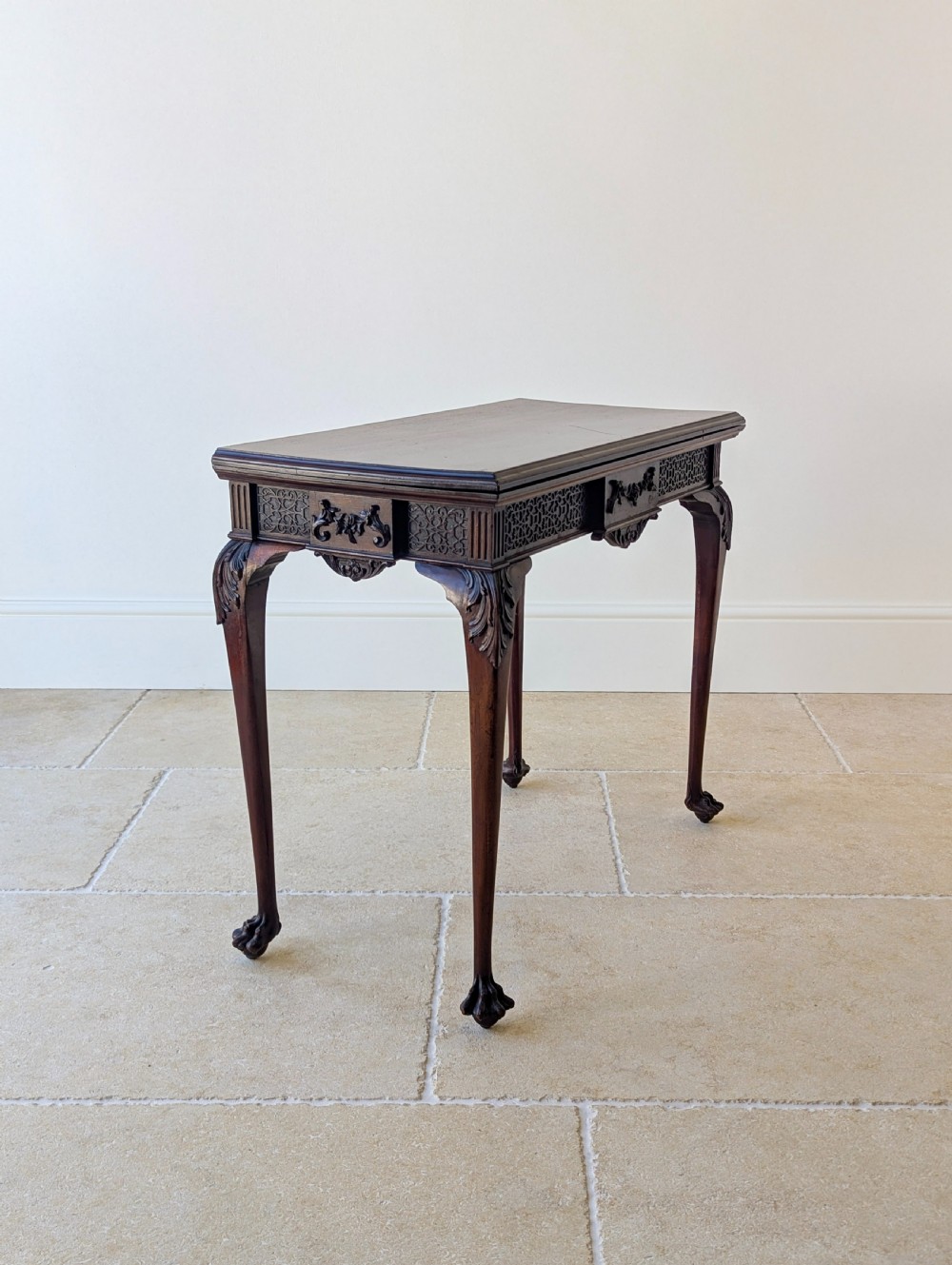 An Edwardian dark mahogany fold-over card table featuring carved cabriole legs, claw and ball feet, and blind fretwork along the apron. View XIII