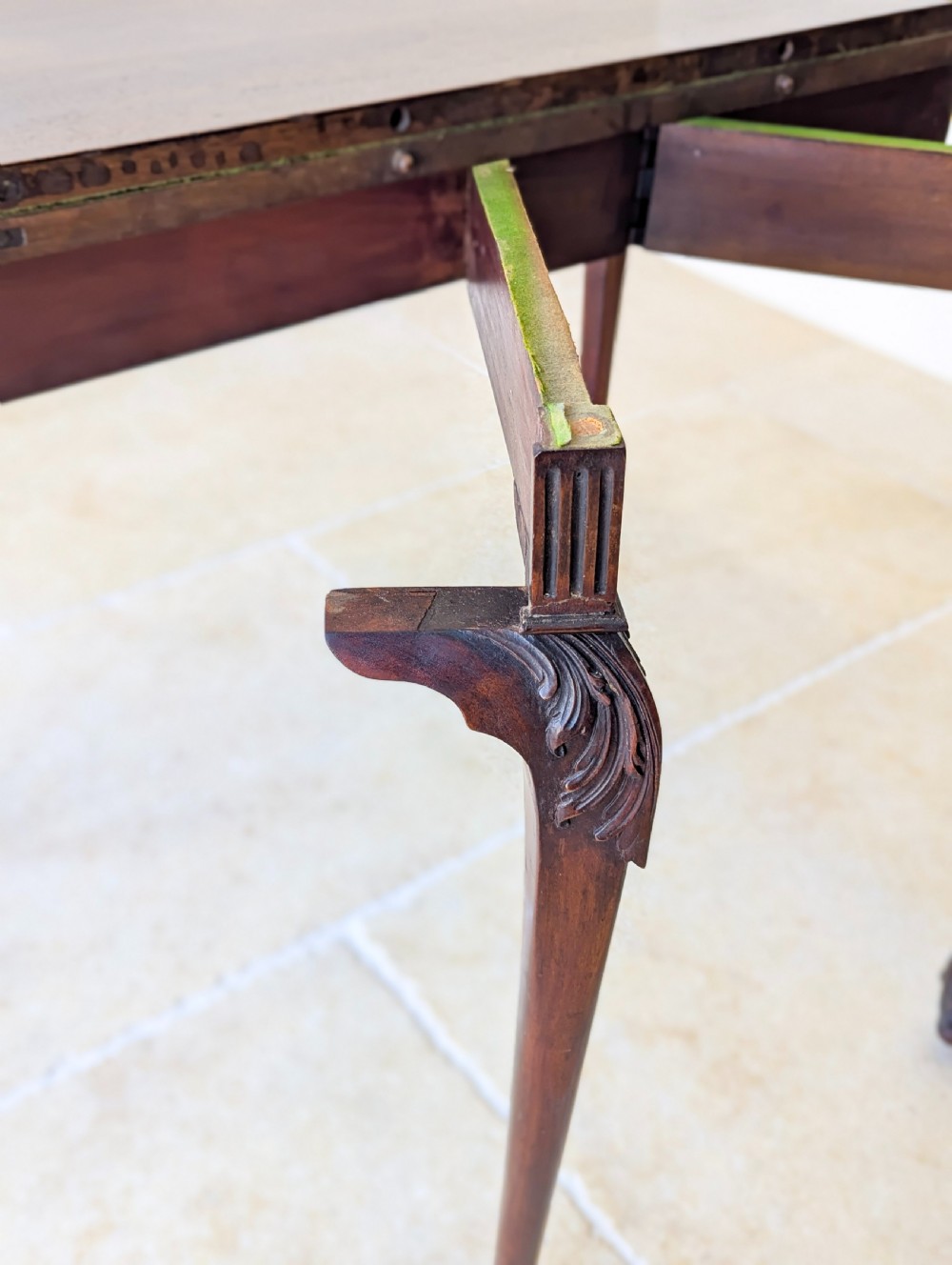 An Edwardian dark mahogany fold-over card table featuring carved cabriole legs, claw and ball feet, and blind fretwork along the apron. View XIX
