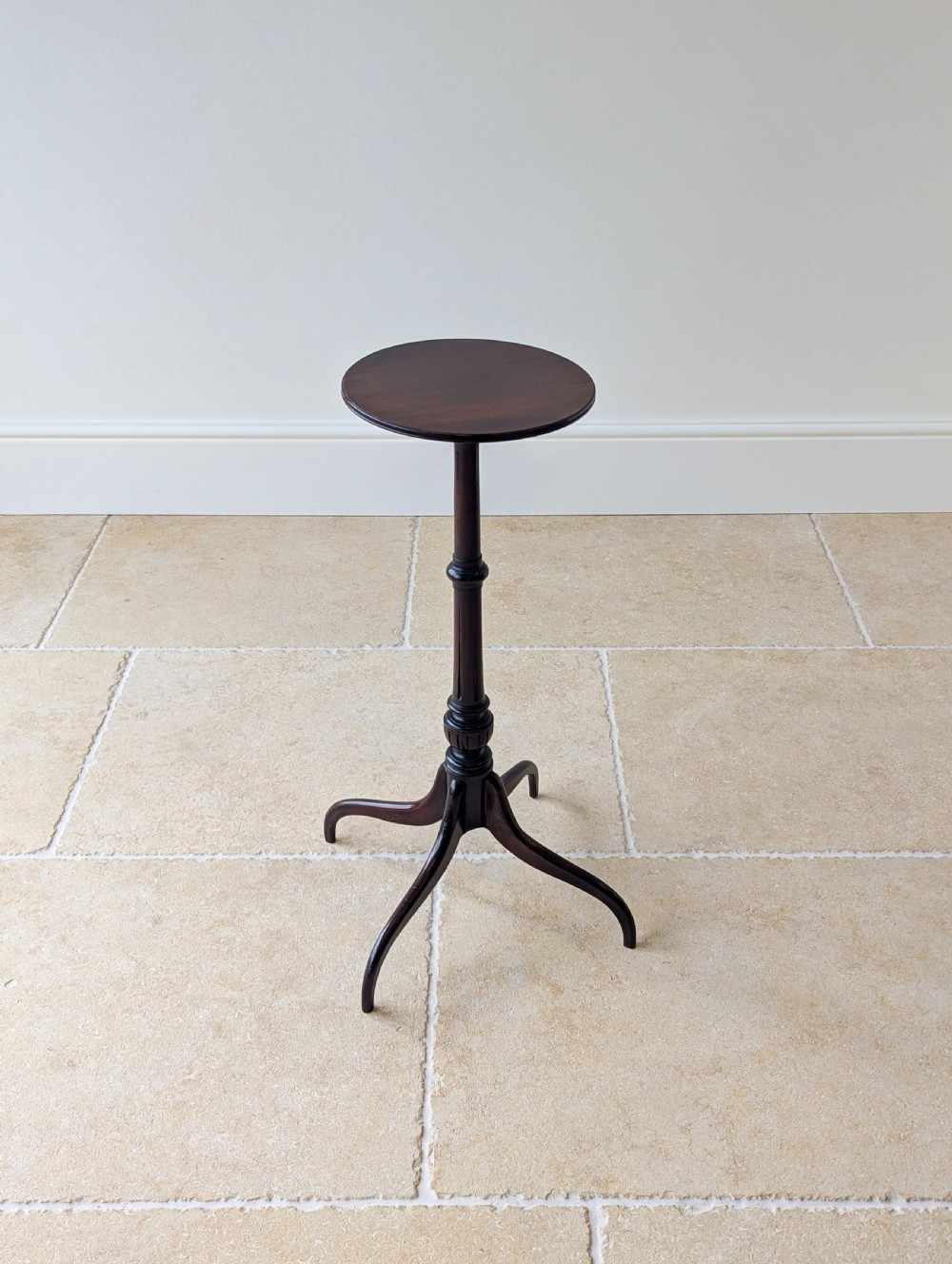 A tall, slender dark walnut torchere featuring a circular flat top, a turned central column, and a sweeping tripod base. View II