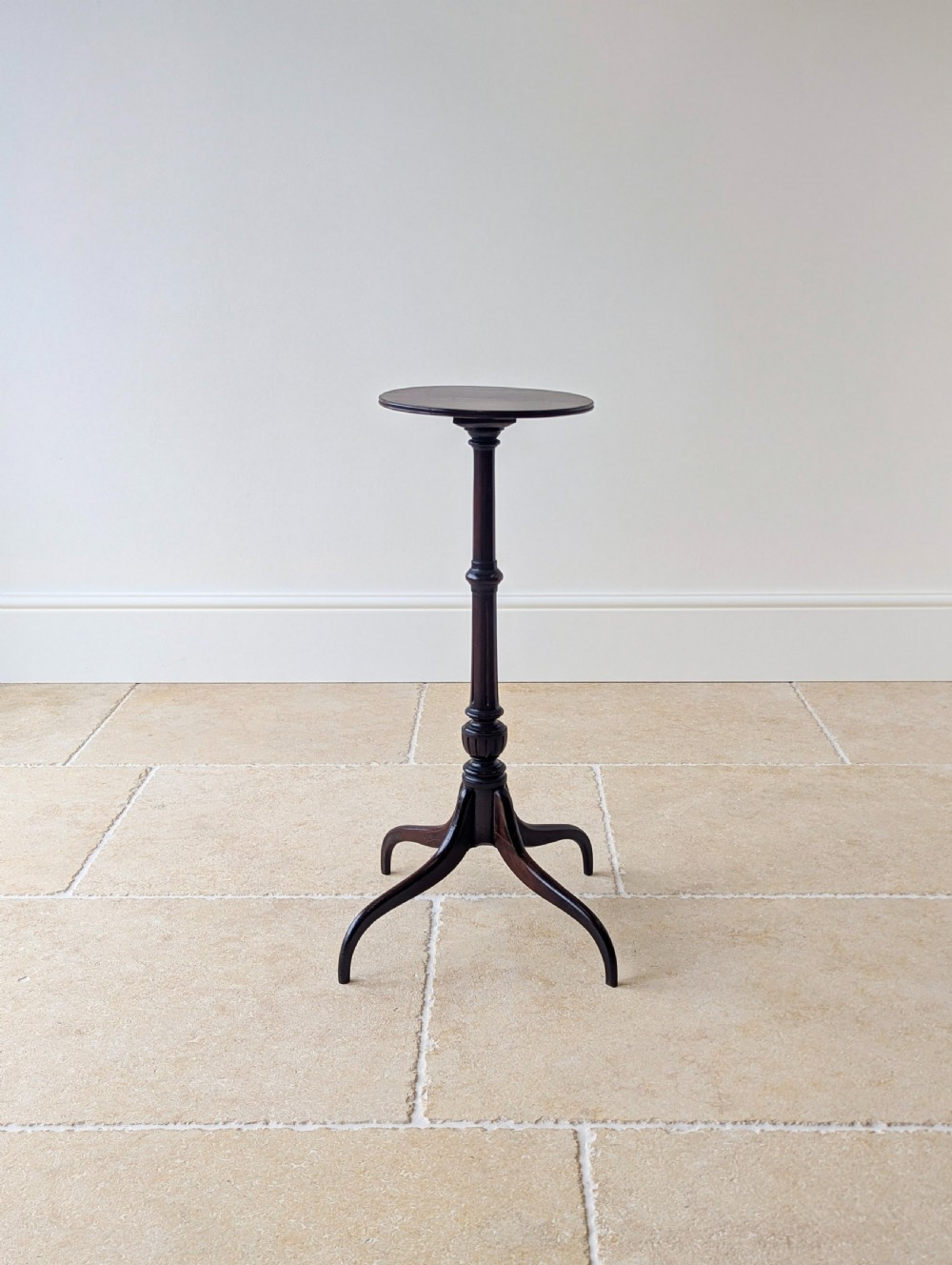 A tall, slender dark walnut torchere featuring a circular flat top, a turned central column, and a sweeping tripod base. View IV