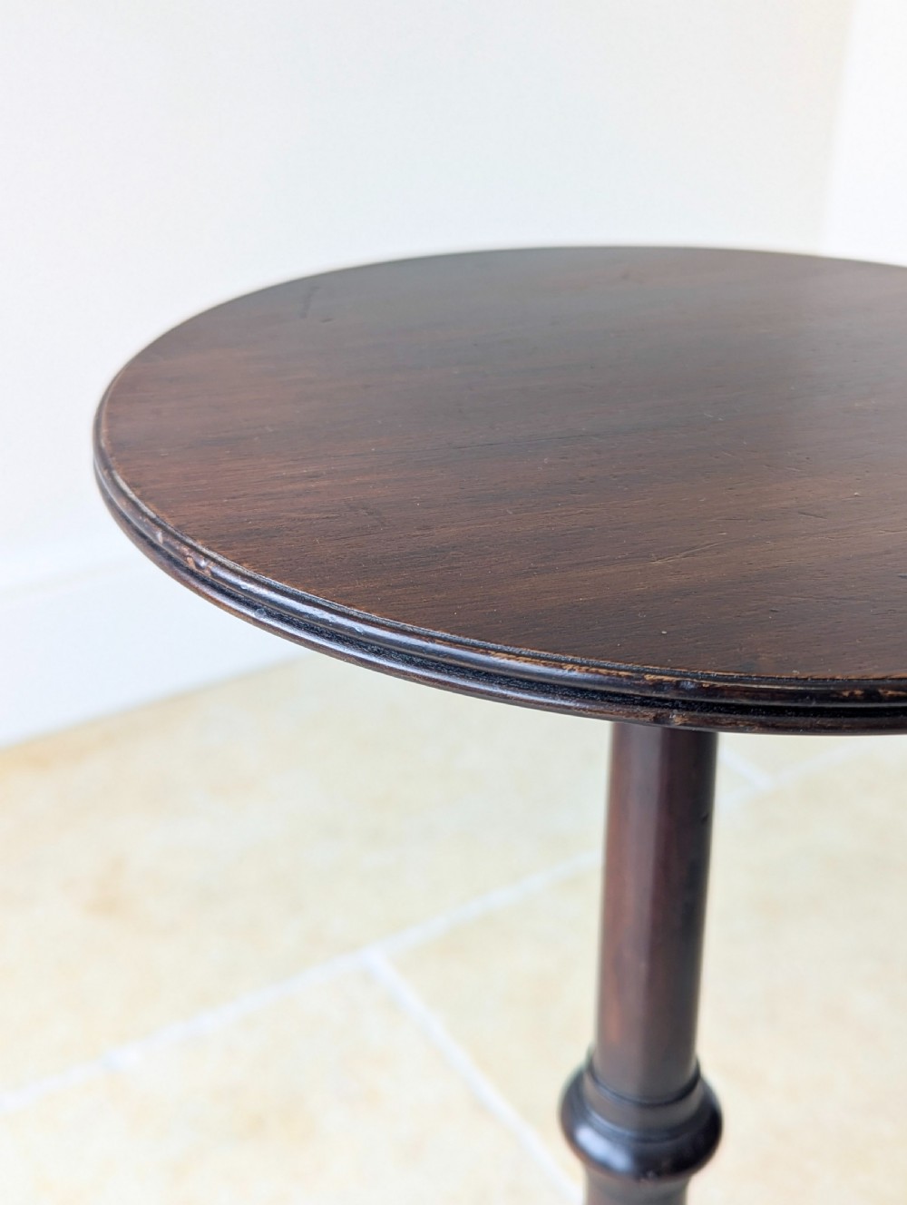 A tall, slender dark walnut torchere featuring a circular flat top, a turned central column, and a sweeping tripod base. View VII