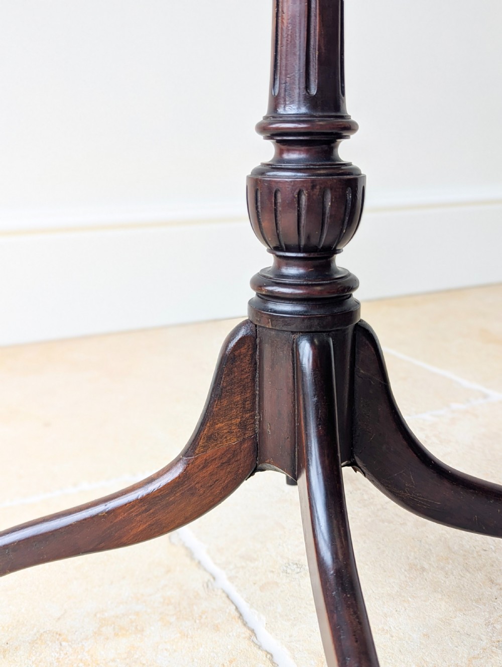 A tall, slender dark walnut torchere featuring a circular flat top, a turned central column, and a sweeping tripod base. View XI