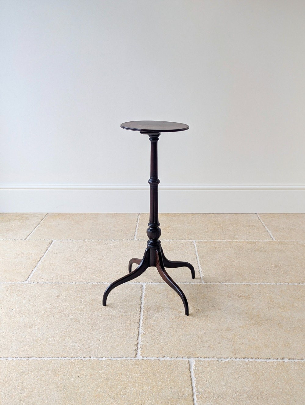 A tall, slender dark walnut torchere featuring a circular flat top, a turned central column, and a sweeping tripod base. View XII
