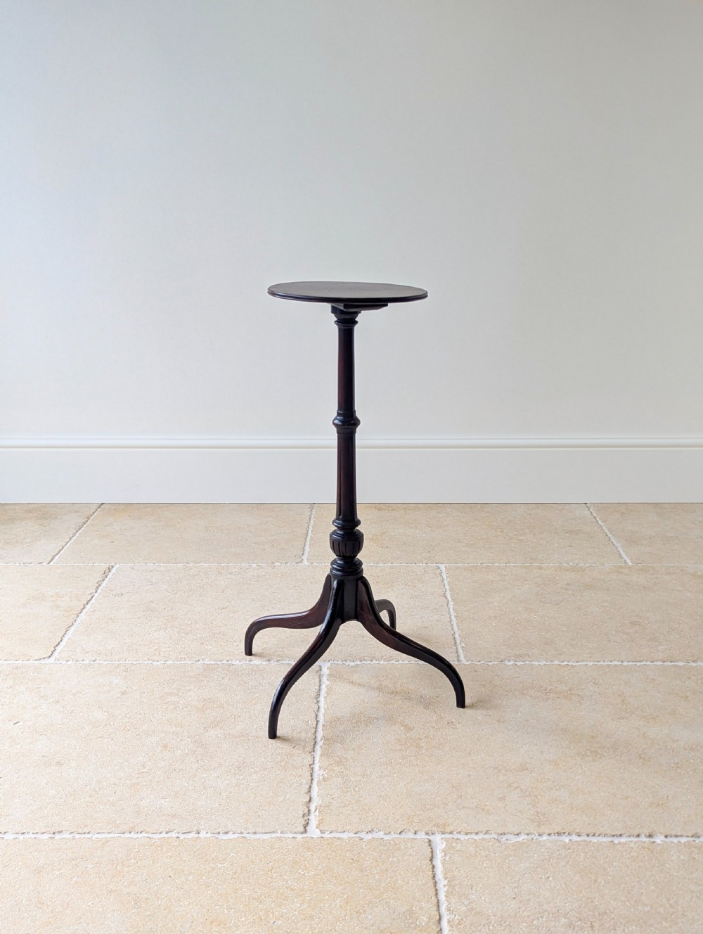 A tall, slender dark walnut torchere featuring a circular flat top, a turned central column, and a sweeping tripod base. View XVII