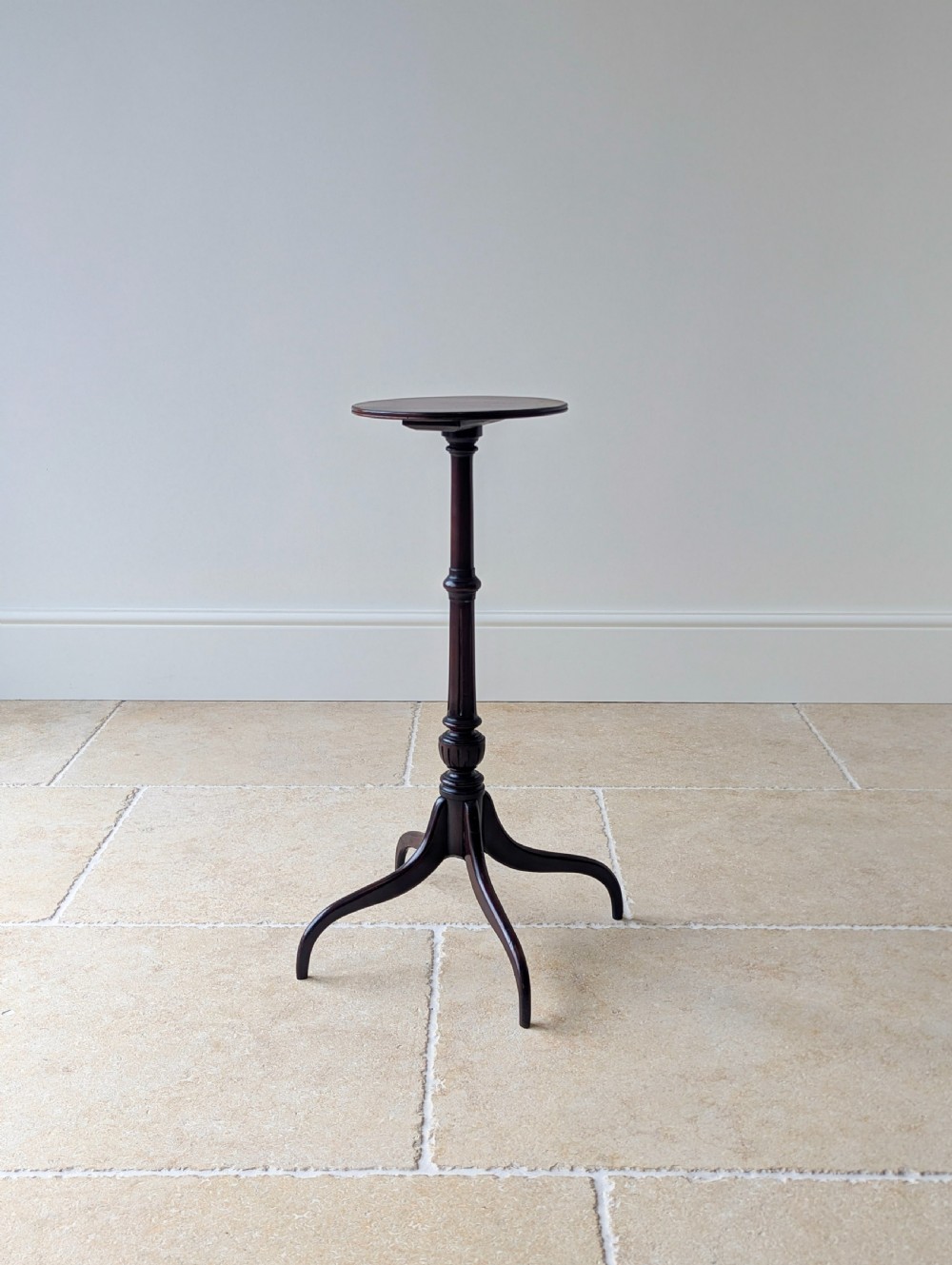 A tall, slender dark walnut torchere featuring a circular flat top, a turned central column, and a sweeping tripod base. View XIX