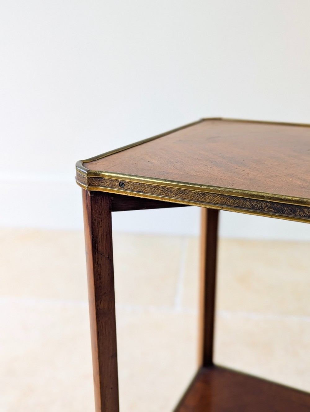 A late Victorian square mahogany two-tier occasional table with cabriole legs, brass-edged rims, and brass castors. View X