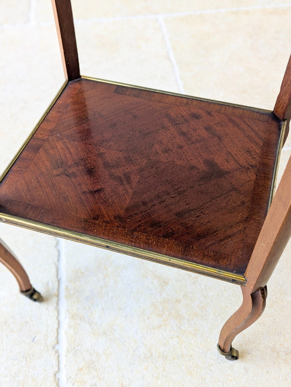 A late Victorian square mahogany two-tier occasional table with cabriole legs, brass-edged rims, and brass castors. View XIII