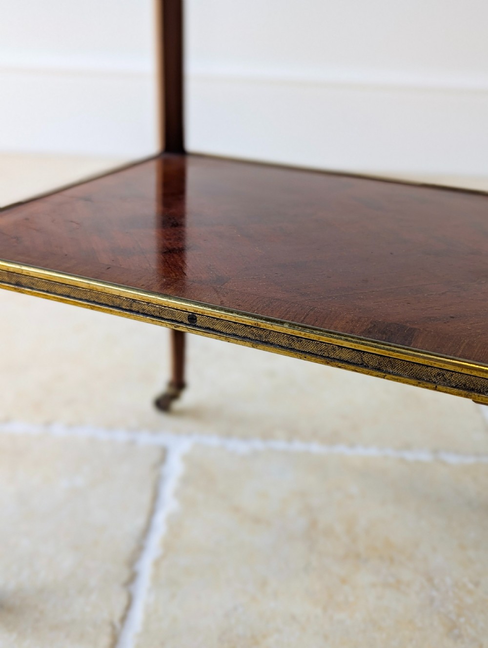 A late Victorian square mahogany two-tier occasional table with cabriole legs, brass-edged rims, and brass castors. View XV