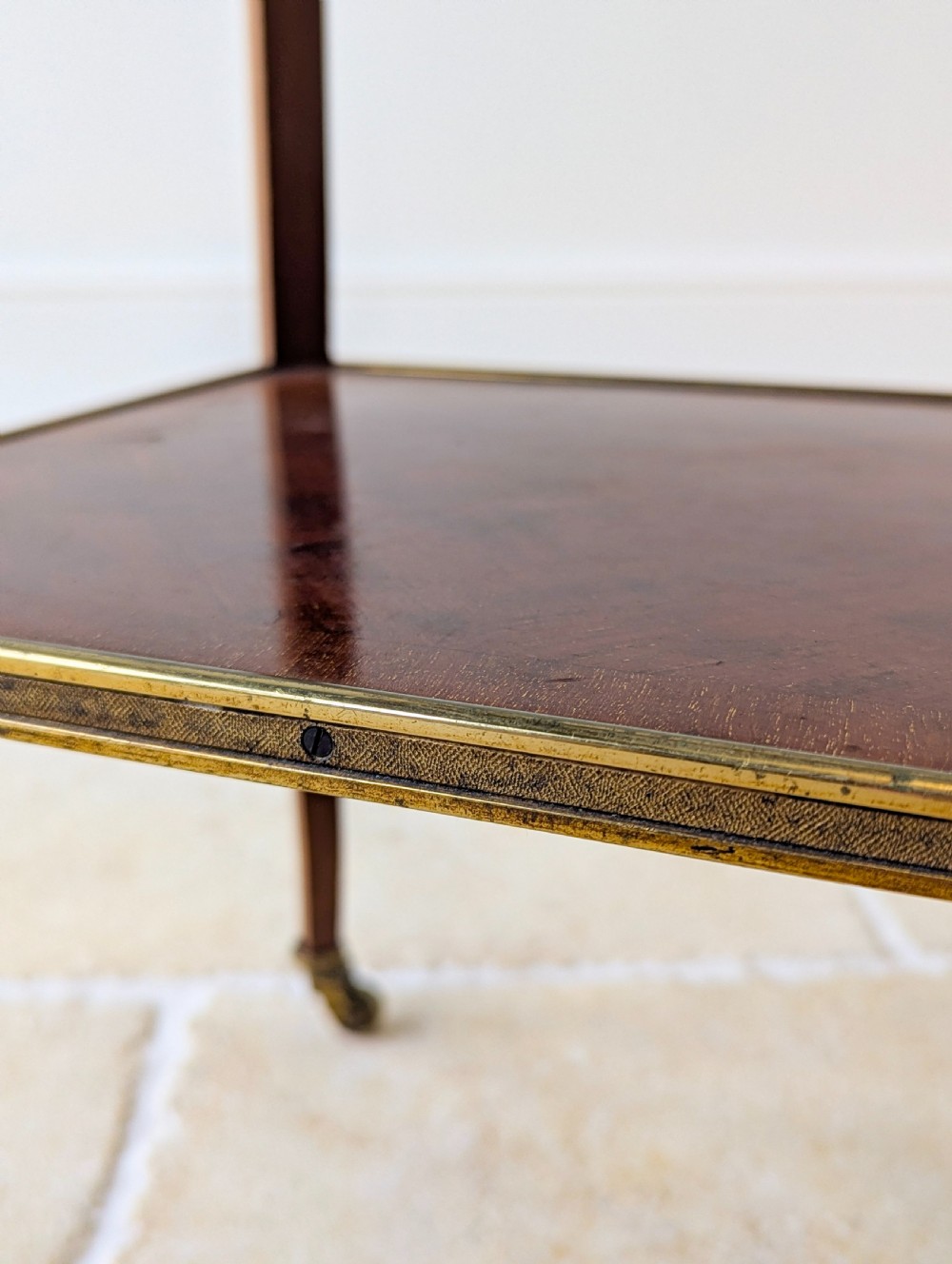 A late Victorian square mahogany two-tier occasional table with cabriole legs, brass-edged rims, and brass castors. View XVII