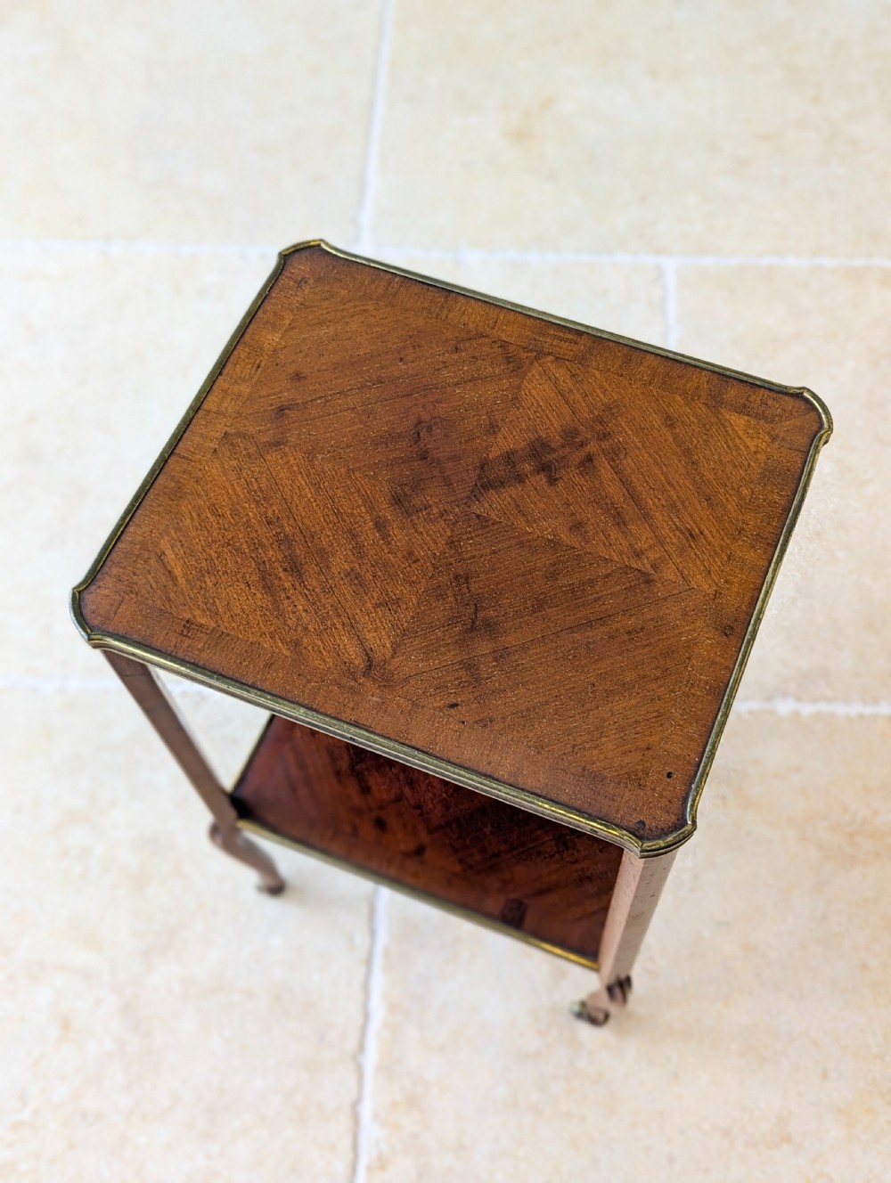 A late Victorian square mahogany two-tier occasional table with cabriole legs, brass-edged rims, and brass castors. View XVIII