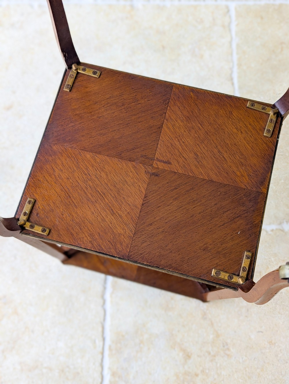 A late Victorian square mahogany two-tier occasional table with cabriole legs, brass-edged rims, and brass castors. View XX