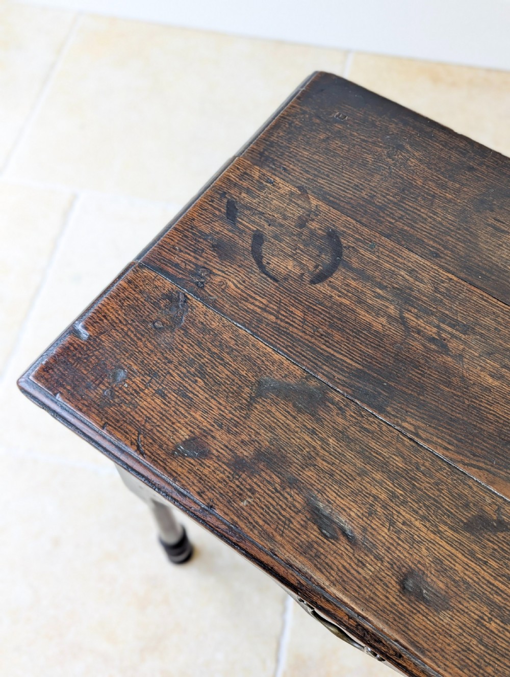 A dark oak Georgian lowboy featuring a single drawer with a brass drop handle, shaped frieze, and turned legs. View IX