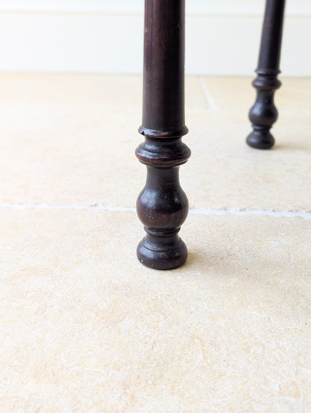 A dark oak Georgian lowboy featuring a single drawer with a brass drop handle, shaped frieze, and turned legs. View X