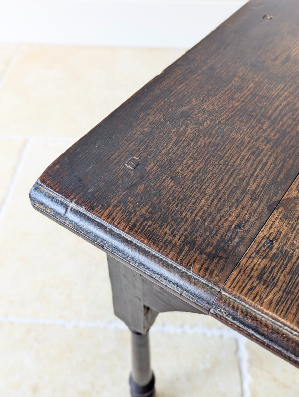A dark oak Georgian lowboy featuring a single drawer with a brass drop handle, shaped frieze, and turned legs. View XV