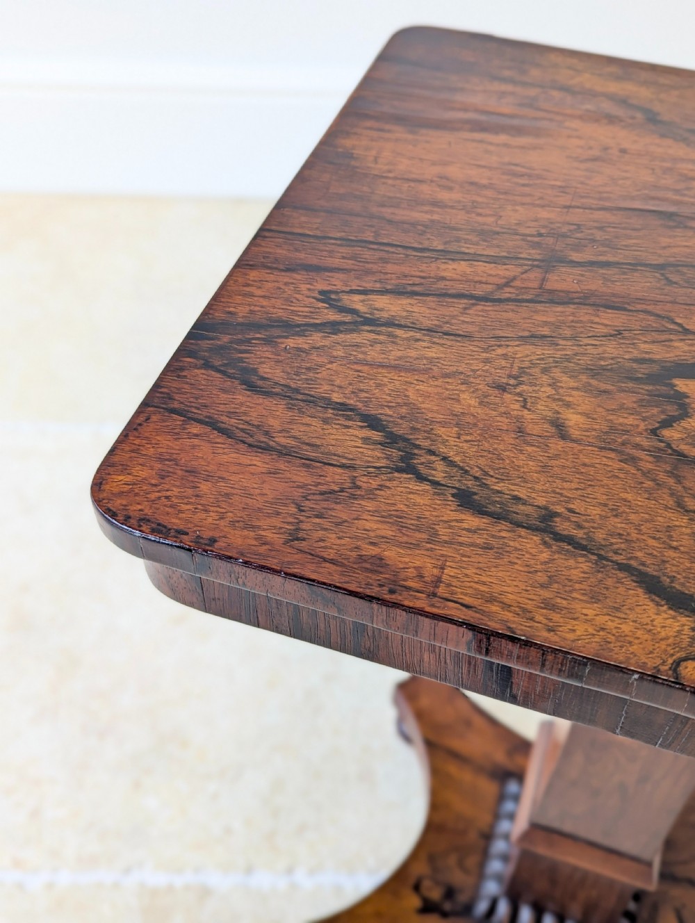A Regency rosewood occasional table with a rectangular top, square column pedestal, and quadform base on compressed feet. View XII