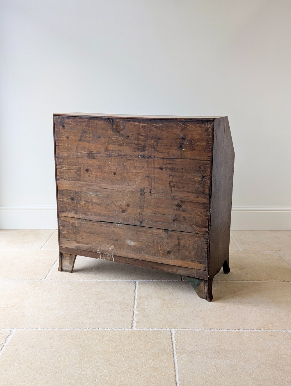 An antique Georgian mahogany slant-front bureau featuring four graduated long drawers with brass oval drop handles and shaped bracket feet. View XX