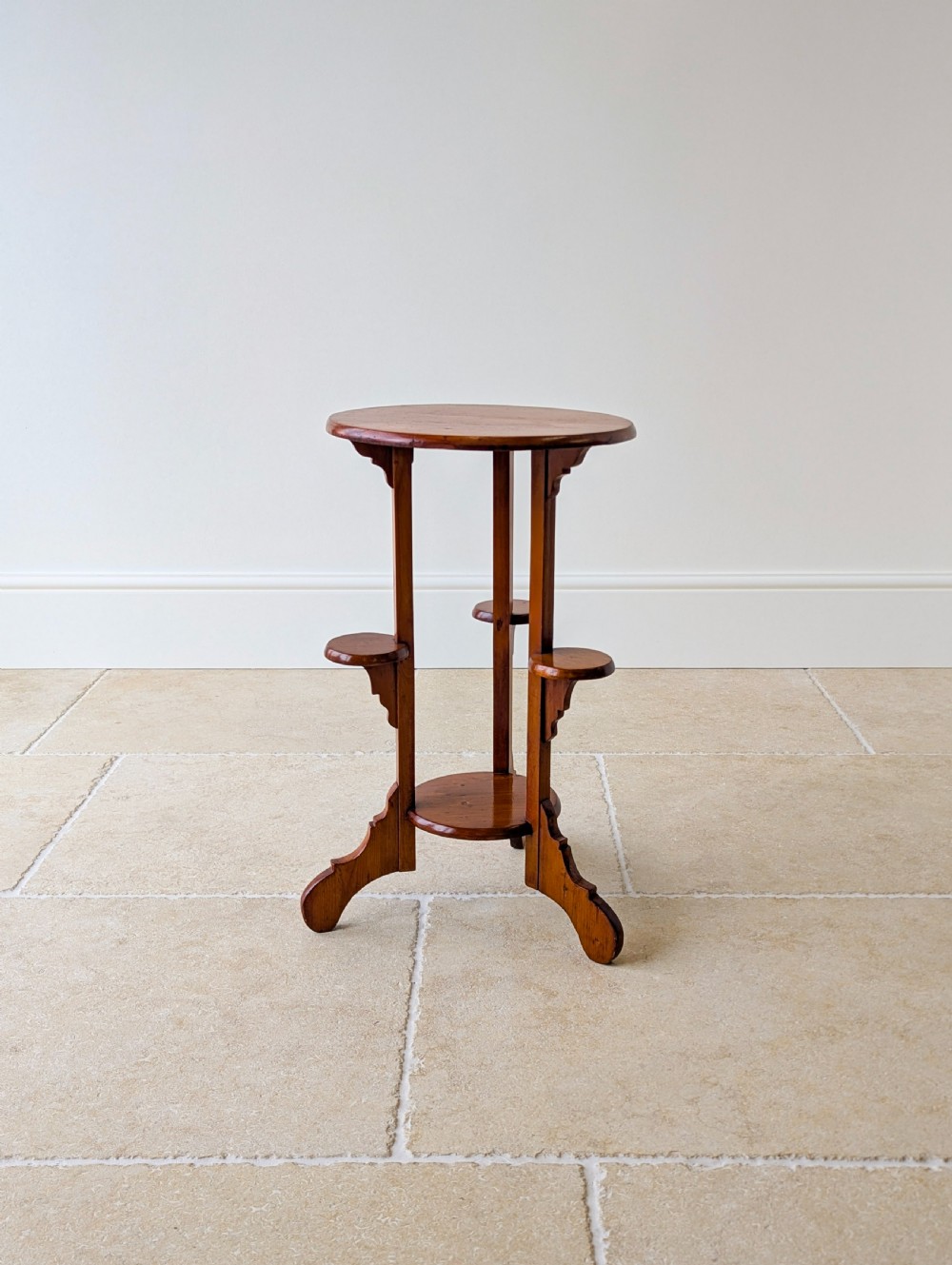 An early 20th-century stained beech occasional table featuring a circular top, three small side tiers, a lower circular shelf, and curved bracket feet. View III