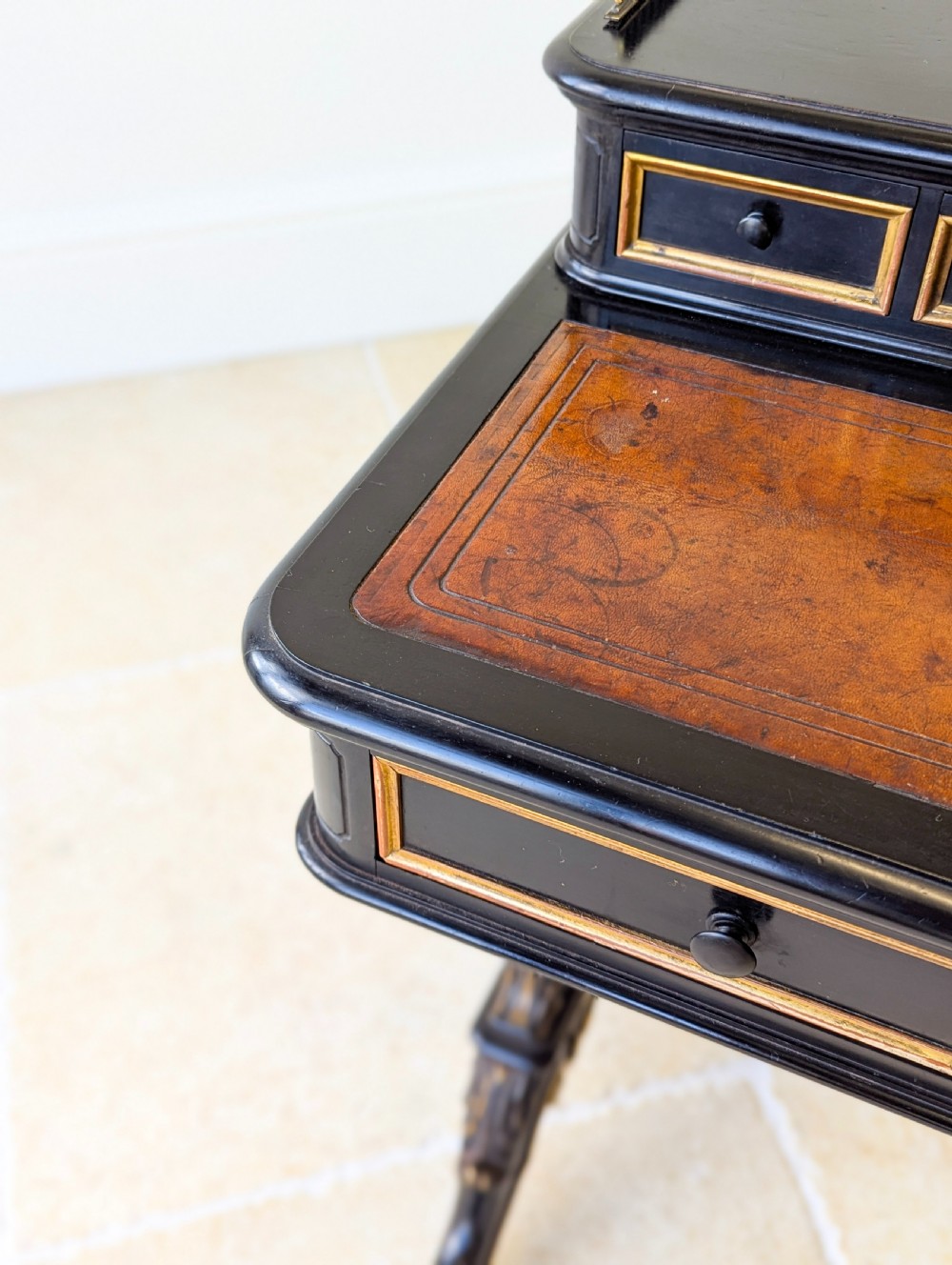 A Victorian ebonised bonheur du jour writing desk featuring gilded accents, a raised superstructure with small drawers, a brass gallery rail, and turned stretcher support. View III