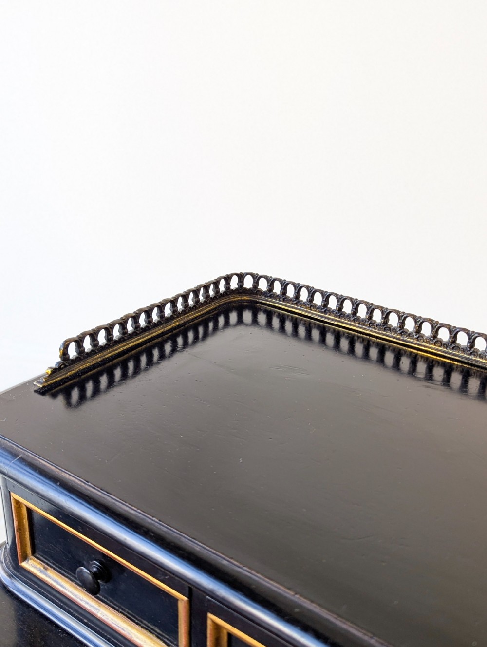 A Victorian ebonised bonheur du jour writing desk featuring gilded accents, a raised superstructure with small drawers, a brass gallery rail, and turned stretcher support. View VII