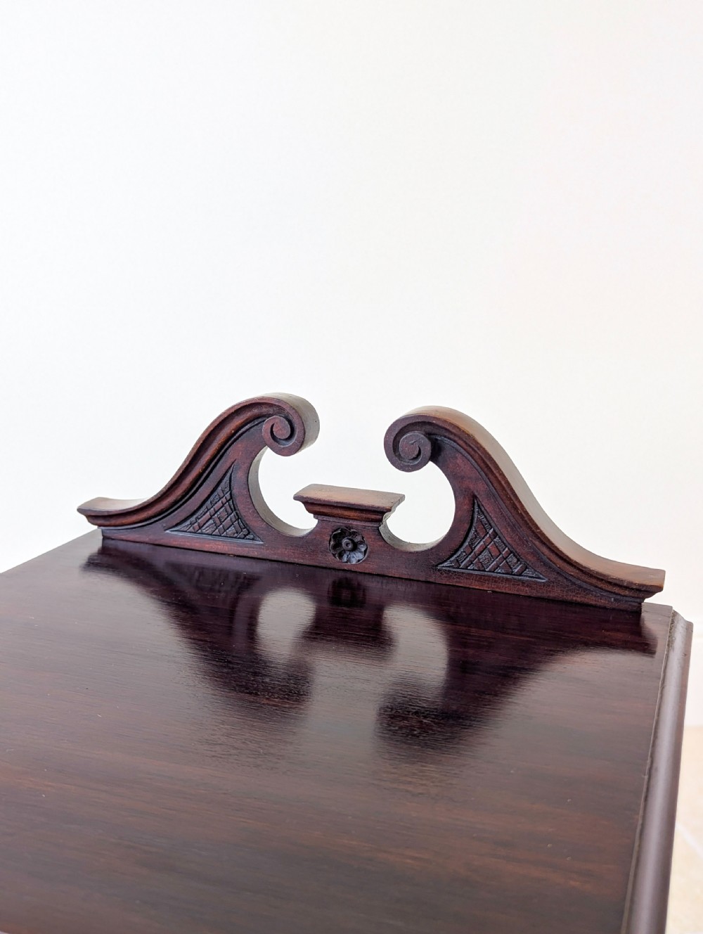 An antique Victorian dark mahogany bedside cabinet with a carved gallery back, a single door with a molded panel, and a sturdy plinth base. View XI
