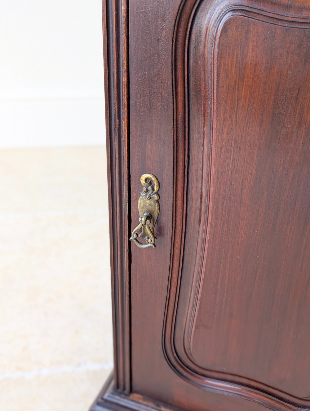 An antique Victorian dark mahogany bedside cabinet with a carved gallery back, a single door with a molded panel, and a sturdy plinth base. View XIII