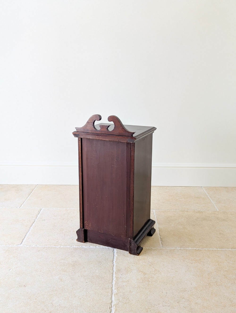 An antique Victorian dark mahogany bedside cabinet with a carved gallery back, a single door with a molded panel, and a sturdy plinth base. View XIV