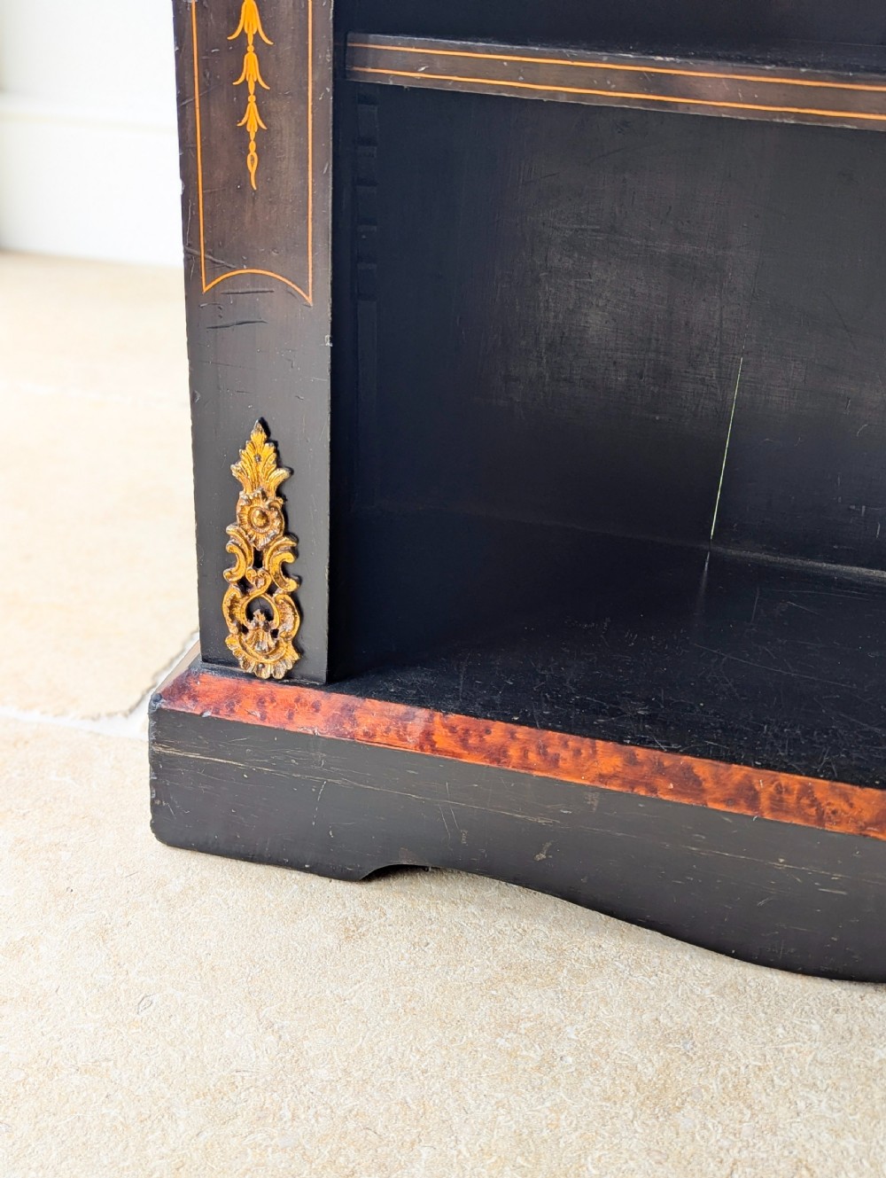 A Victorian ebonised open bookcase with three shelves, gold inlay, and gilt bronze mounts along the side uprights. View XII