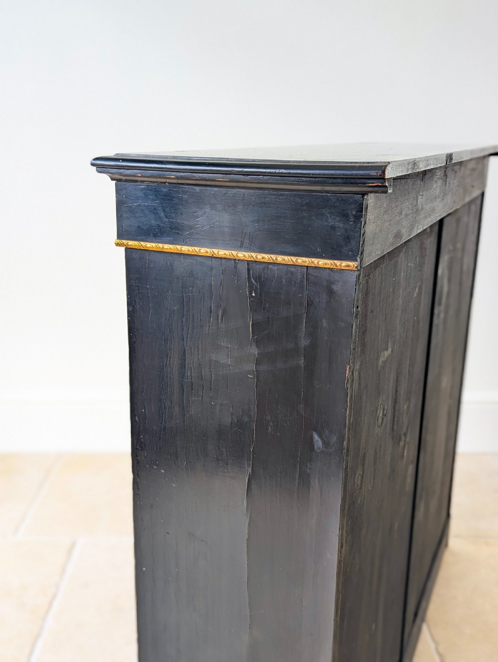 A Victorian ebonised open bookcase with three shelves, gold inlay, and gilt bronze mounts along the side uprights. View XIV