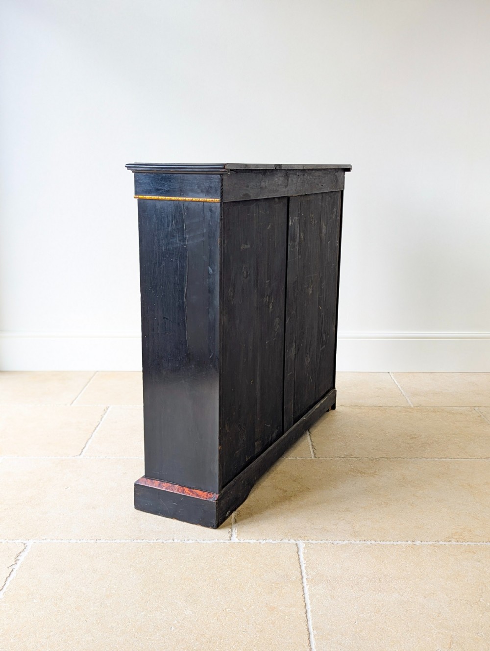 A Victorian ebonised open bookcase with three shelves, gold inlay, and gilt bronze mounts along the side uprights. View XV