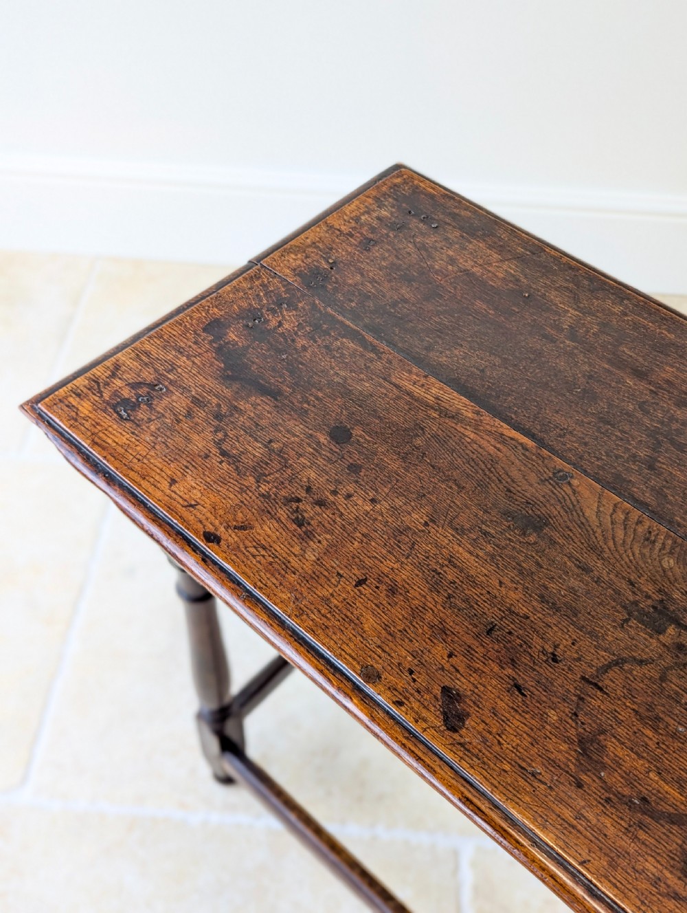 A late 17th-century dark oak side table with turned legs, lower stretchers, and a single drawer featuring brass drop handles. View XIII