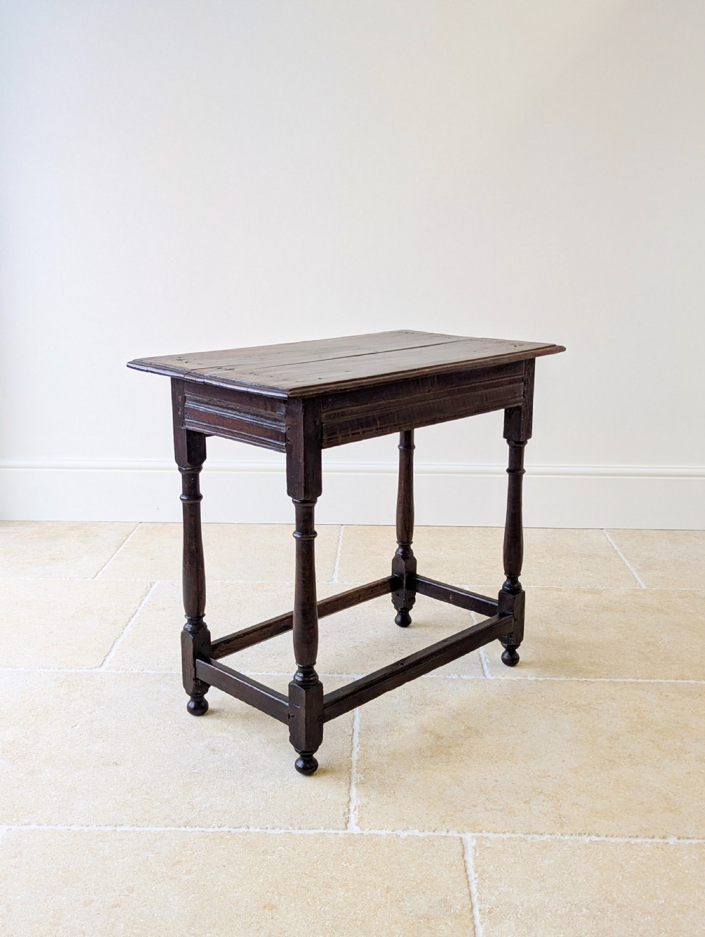 A late 17th-century dark oak side table with turned legs, lower stretchers, and a single drawer featuring brass drop handles. View XVIII