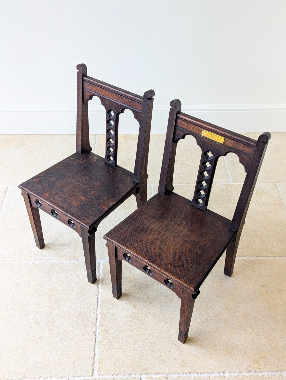 A pair of dark oak Edwardian Gothic Revival side chairs displaying trefoil cutouts, pointed arches, and solid square legs. View II