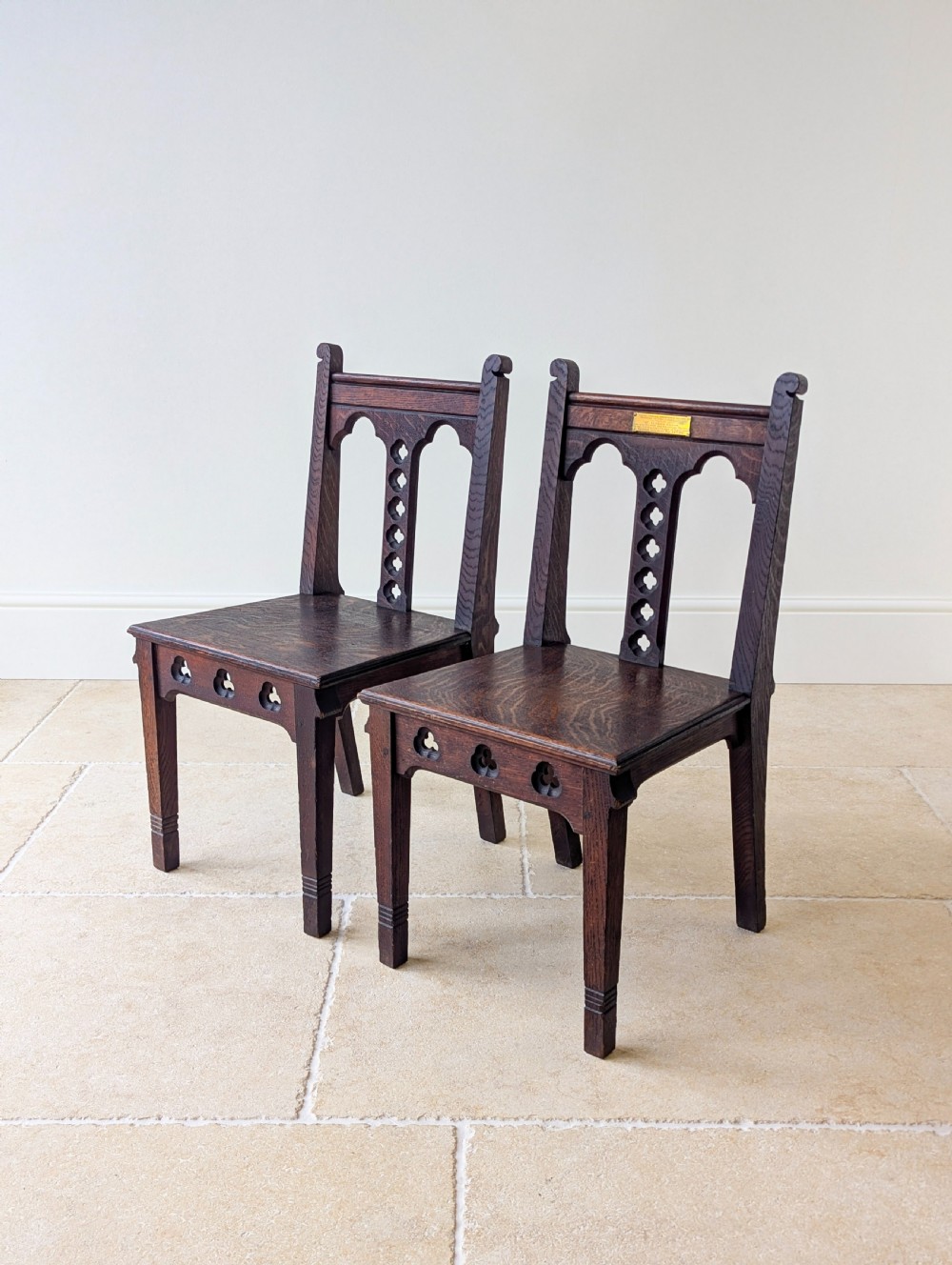 A pair of dark oak Edwardian Gothic Revival side chairs displaying trefoil cutouts, pointed arches, and solid square legs. View III