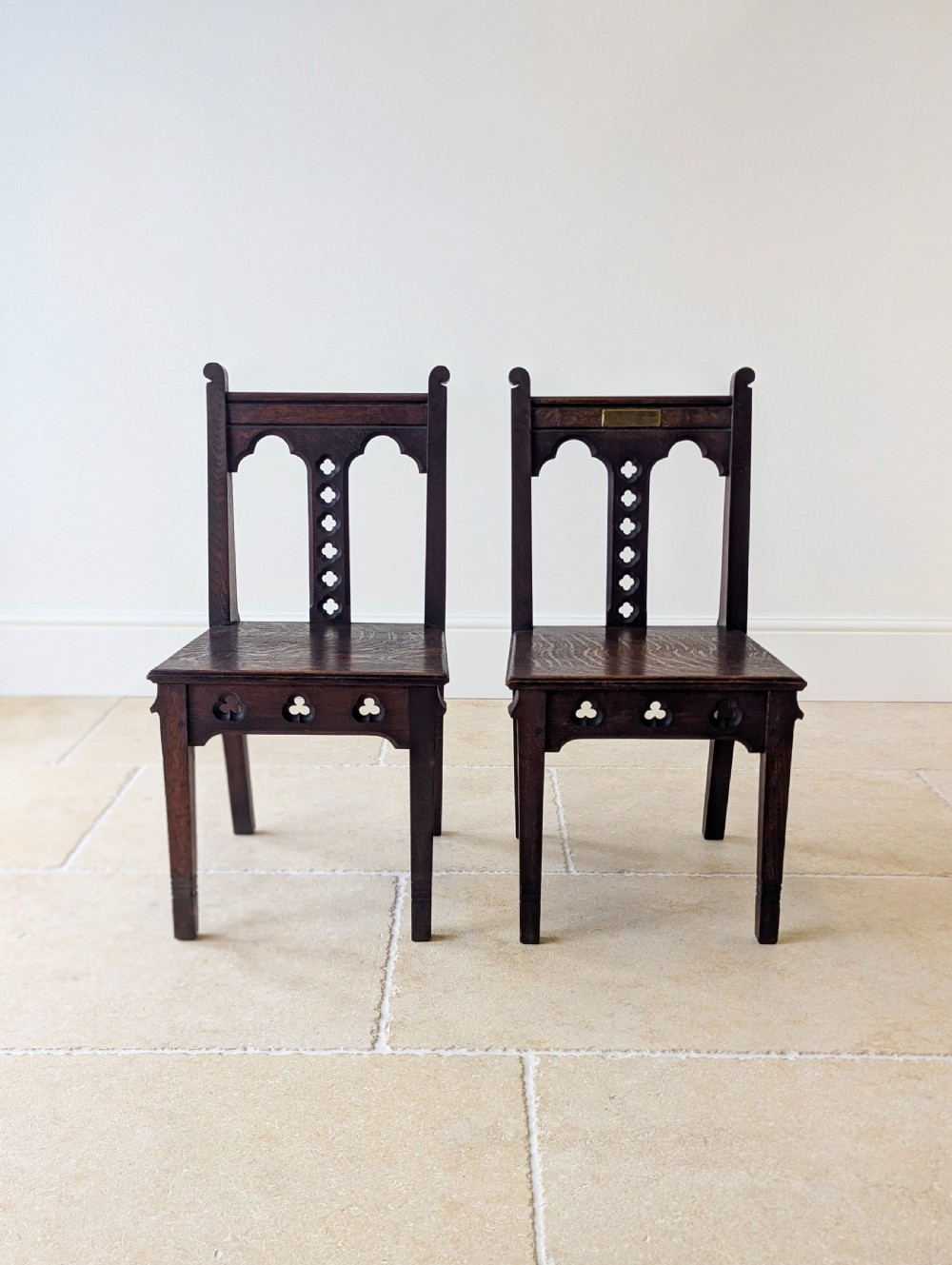 A pair of dark oak Edwardian Gothic Revival side chairs displaying trefoil cutouts, pointed arches, and solid square legs. View VII