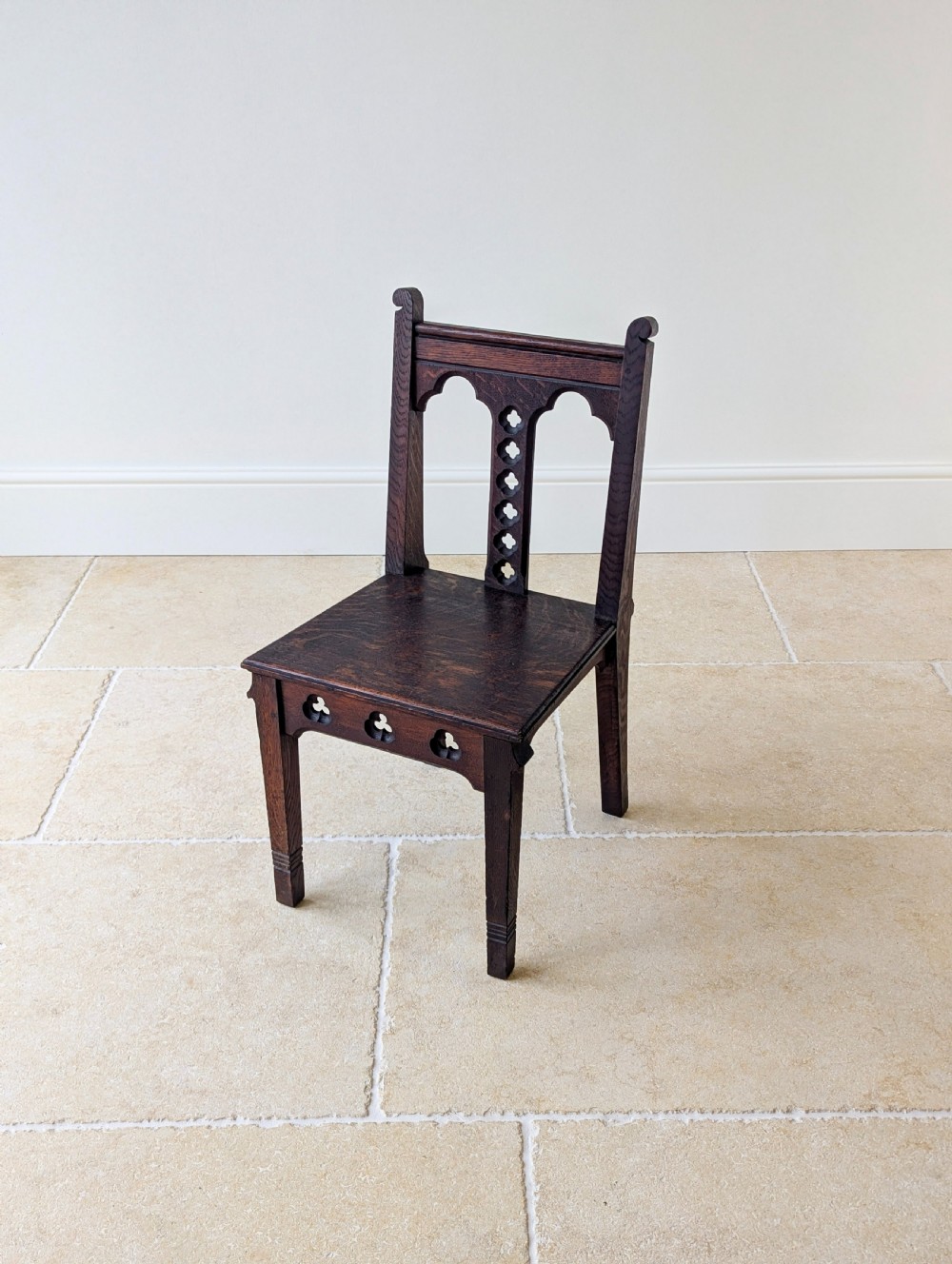 A pair of dark oak Edwardian Gothic Revival side chairs displaying trefoil cutouts, pointed arches, and solid square legs. View XI