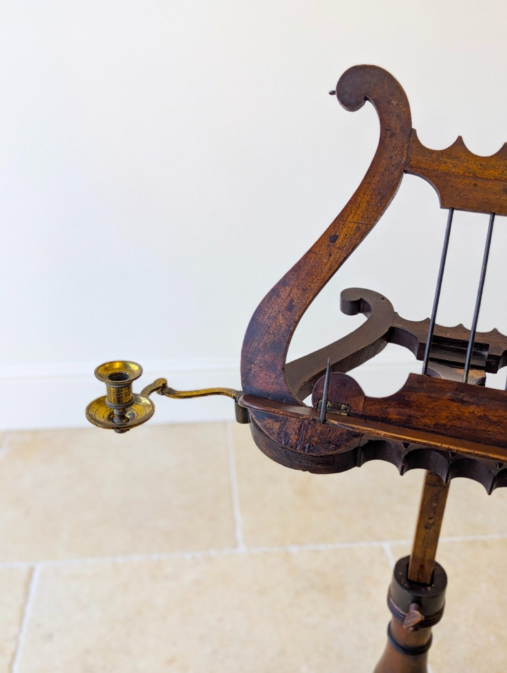 An antique mahogany music stand featuring a lyre-shaped sheet rest, dual brass candle sconces, a turned stem, and a carved tripod base. View VIII