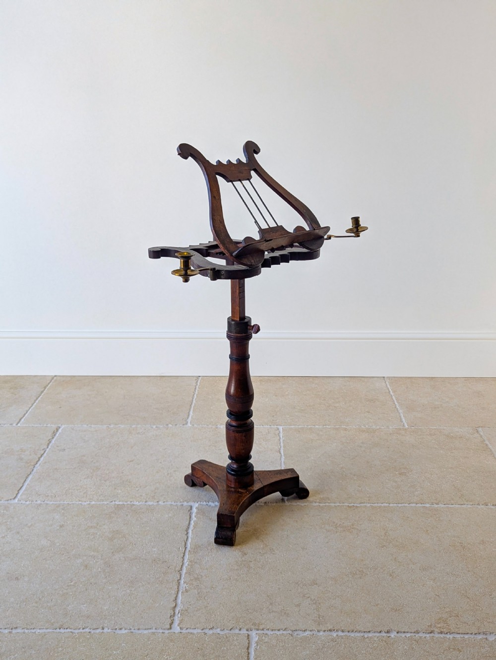 An antique mahogany music stand featuring a lyre-shaped sheet rest, dual brass candle sconces, a turned stem, and a carved tripod base. View XIII