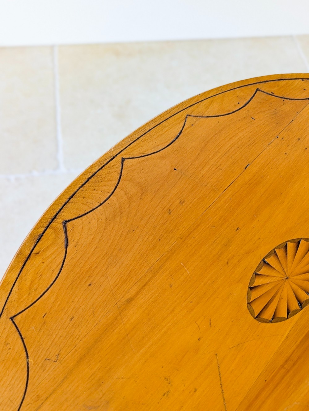 An Edwardian oval satinwood occasional table featuring delicate marquetry inlay on the top, slender splayed legs, and a small oval undertier. View IV