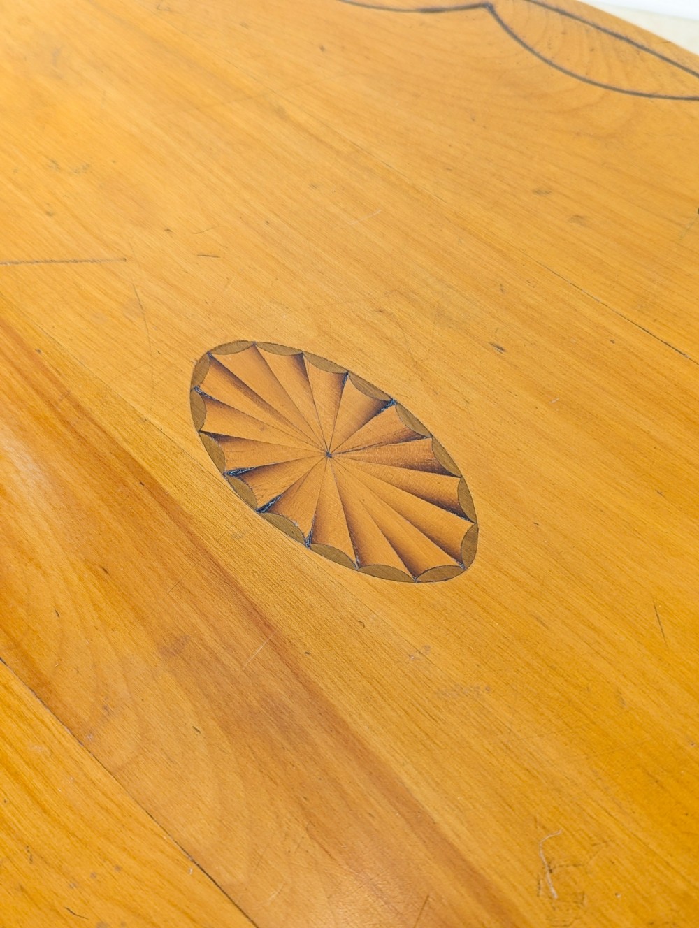An Edwardian oval satinwood occasional table featuring delicate marquetry inlay on the top, slender splayed legs, and a small oval undertier. View VII
