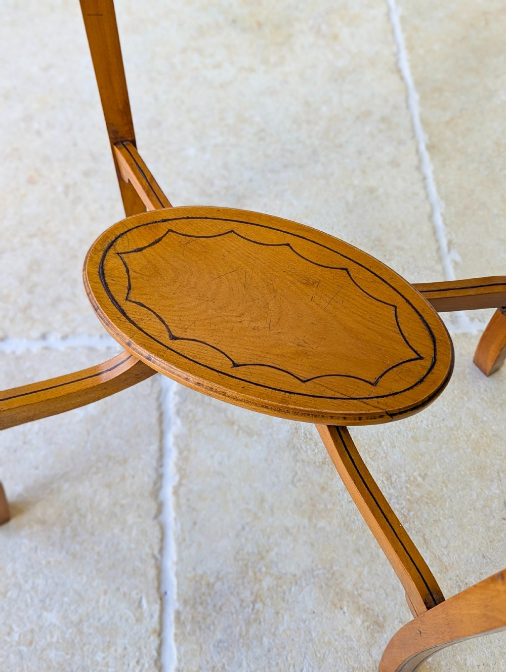 An Edwardian oval satinwood occasional table featuring delicate marquetry inlay on the top, slender splayed legs, and a small oval undertier. View XII