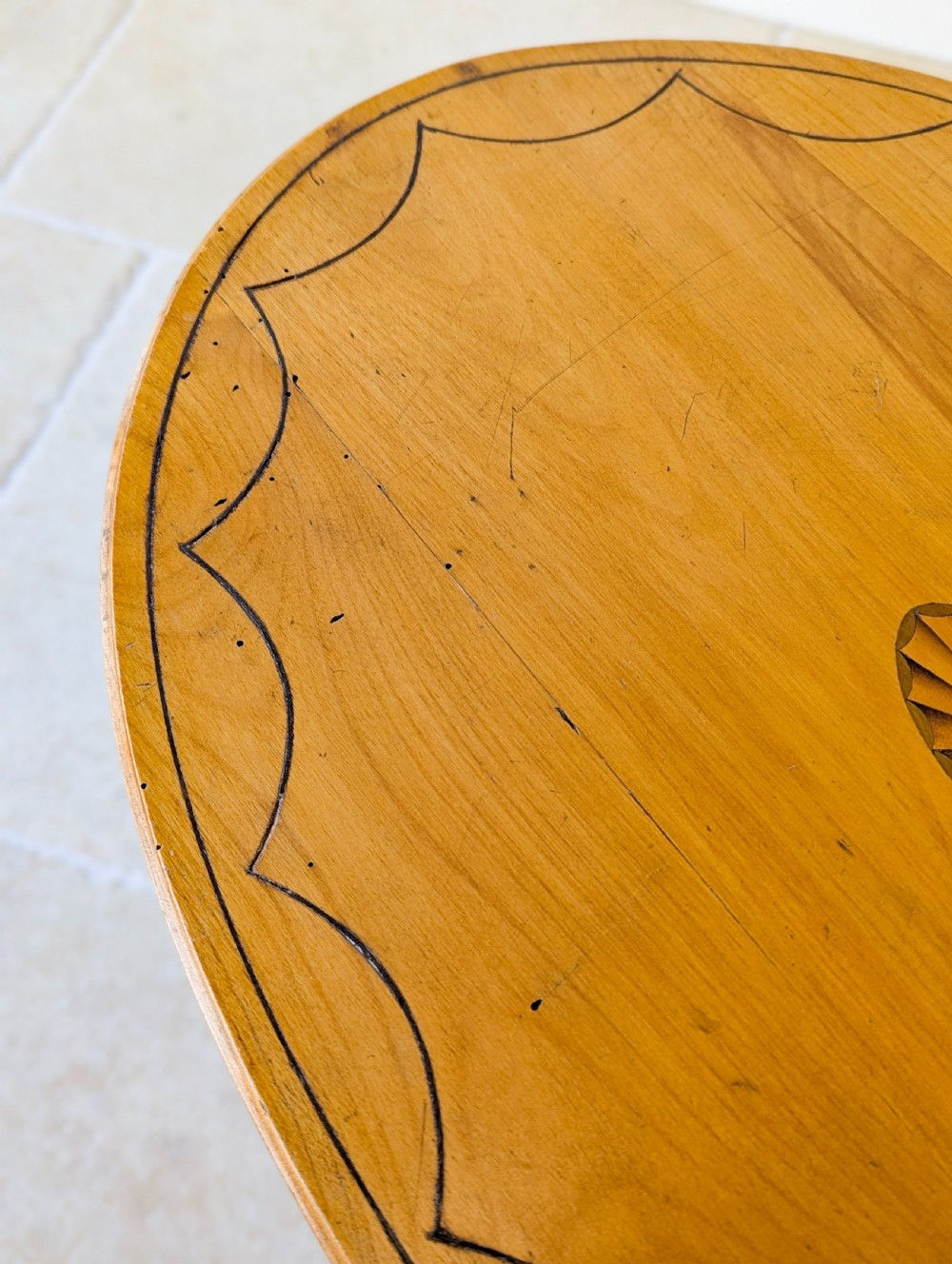 An Edwardian oval satinwood occasional table featuring delicate marquetry inlay on the top, slender splayed legs, and a small oval undertier. View XVI
