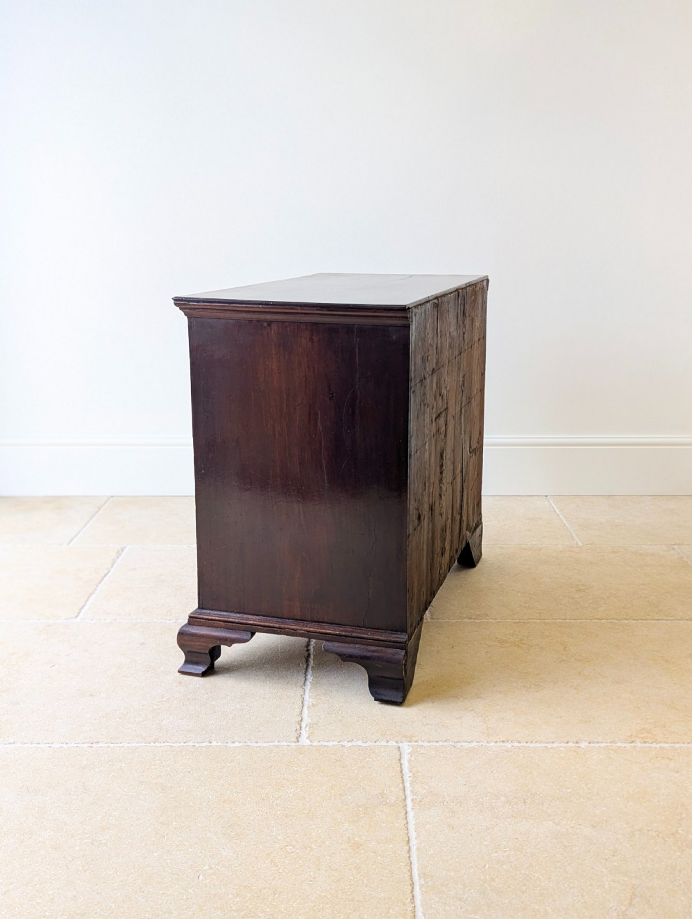 An antique George II mahogany chest of drawers featuring four graduated drawers with ornate brass handles on bracket feet. View XVIII